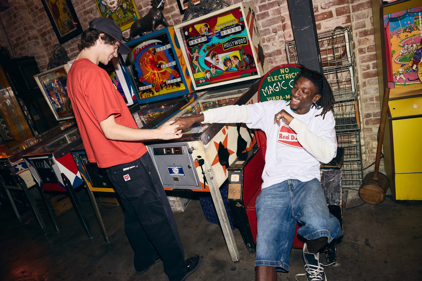 Two models laughing in a Hollywood pinball arcade